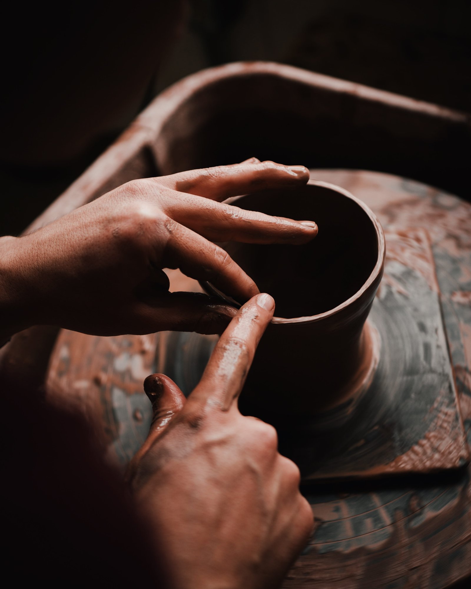 Indian artisan shaping clay on pottery wheel